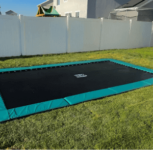 In-ground trampoline on grassy lawn.