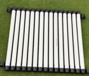 White tubes with black caps on grass.