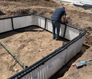 Man building a rectangular swimming pool.